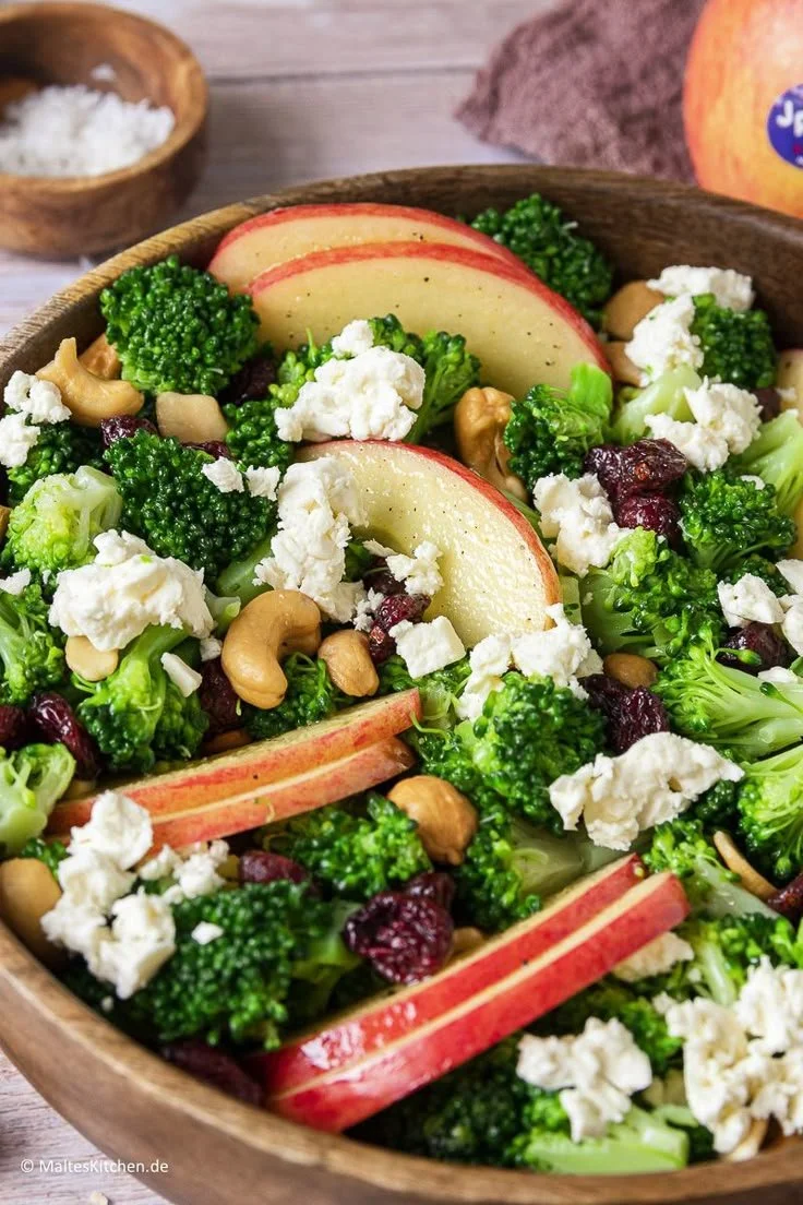 Frischer Brokkoli-Salat mit Äpfeln, Nüssen und Feta auf einem Teller