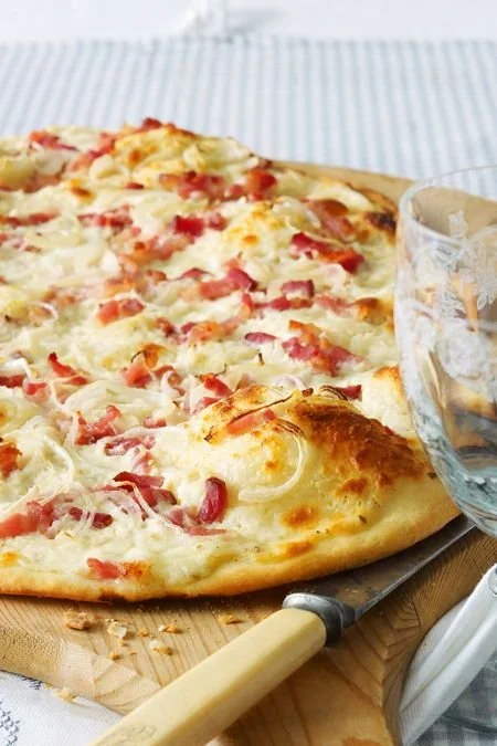 Elsässer Flammkuchen frisch aus dem Ofen, lecker und knusprig zubereitet.