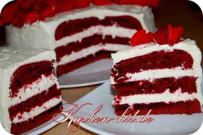 Red Velvet Torte auf einem weißen Teller, garniert mit Sahne und roten Früchten.