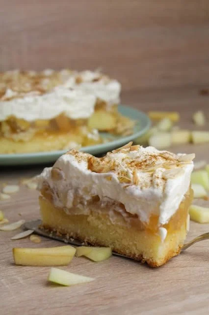 Apfel-Schmand-Torte mit Zimtgestöber auf einem rustikalen Holzgrund